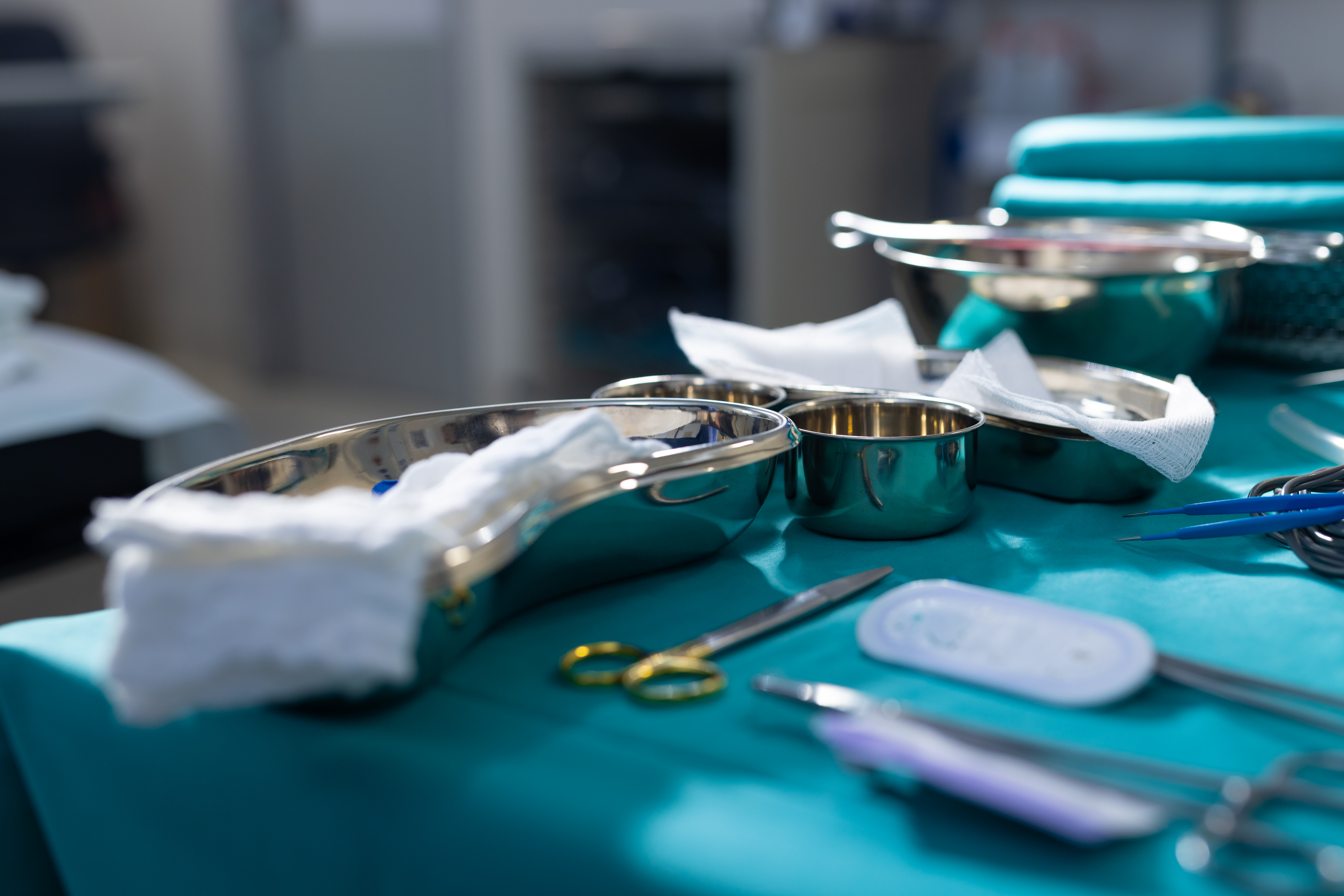 Close up of surgical instruments on table in operation theater at hospital. Hospital, surgery, medicine and healthcare.
